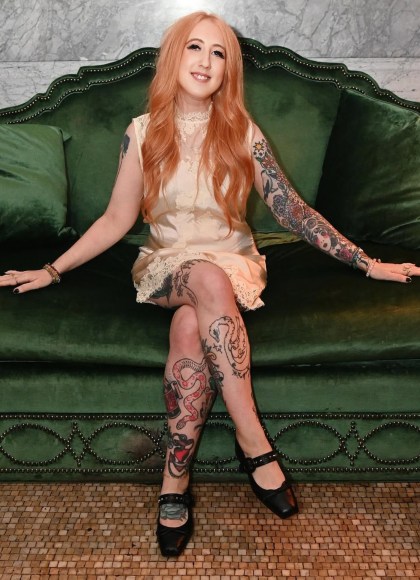 Photo of author Sarah Potter sitting on a green couch and smiling at the camera